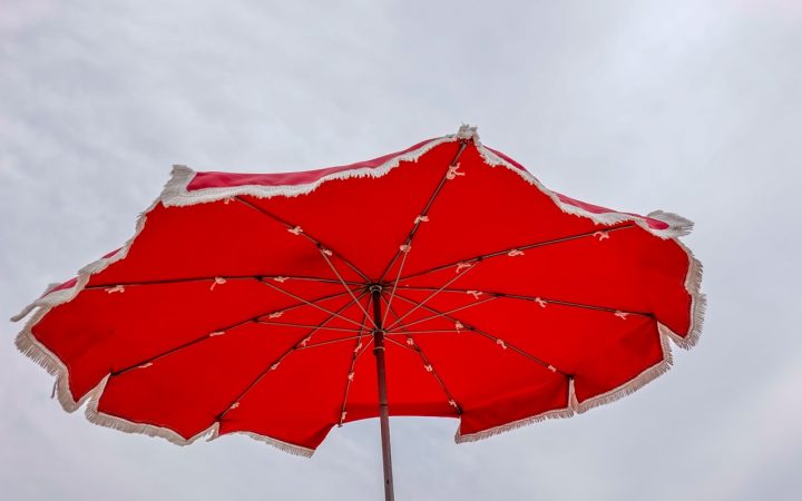 Rode parasol tegen de lucht