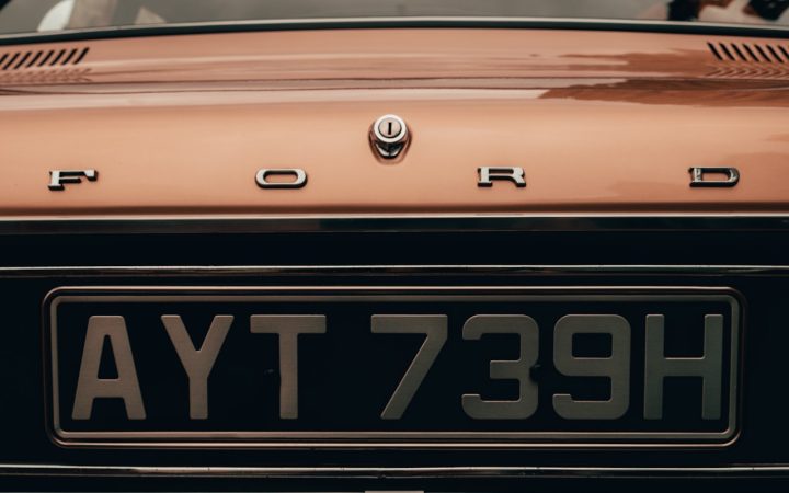 Gele kentekenplaat met zwarte letters op een auto