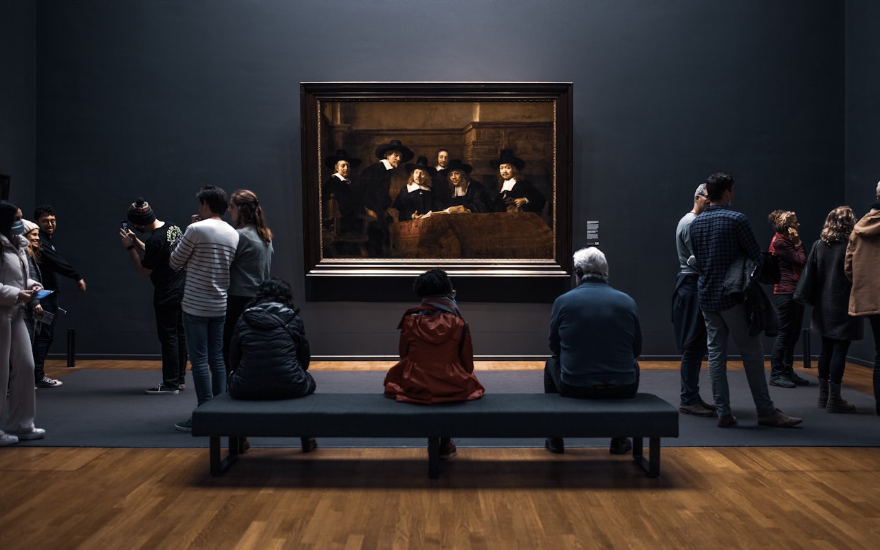 Bezoekers kijken naar De Staalmeesters van Rembrandt in het Rijksmuseum
