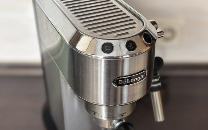 Roestvrijstalen espressomachine met stoompijpje en portafilter op een aanrecht